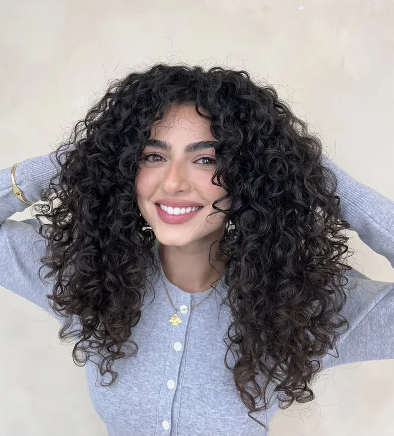 Defined curls with face-framing fringe.